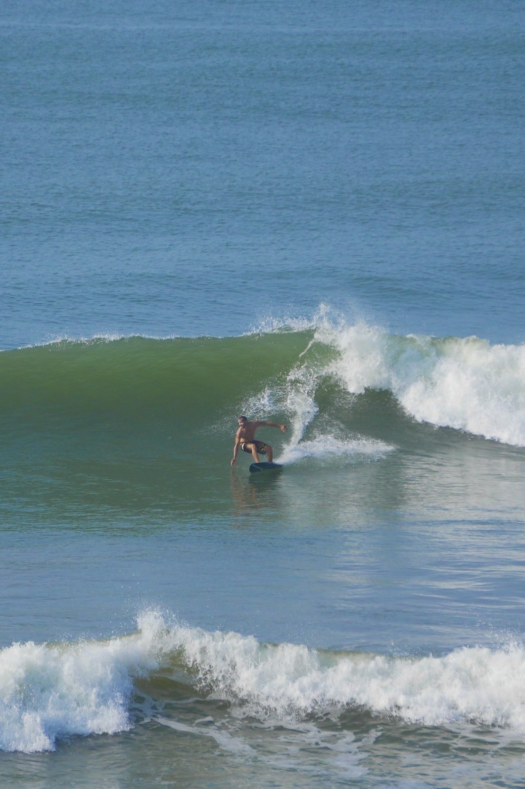 Surfer riding a wave at Dreamer's Surfhouse